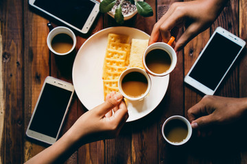 people are drinking coffee,and eating biscuits with fun and happy.