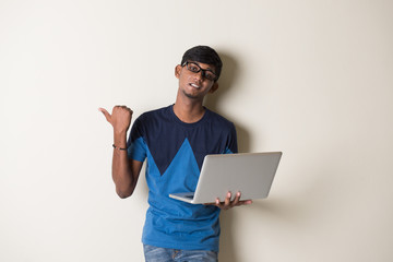 indian teenage male holding laptop