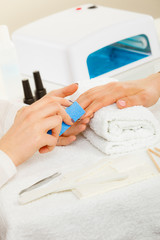 Obraz na płótnie Canvas Woman getting manicure done file nails