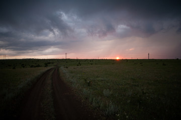 Dark clouds on the gloomy sky over the field and trees rainy sky hurricane clouds and black clouds before the rainstorm