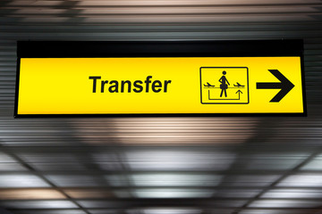 sign transfer with arrow for direction for transit passenger to change air plane for destination. yellow transfer for connecting flight sign at the airport - obrazy, fototapety, plakaty