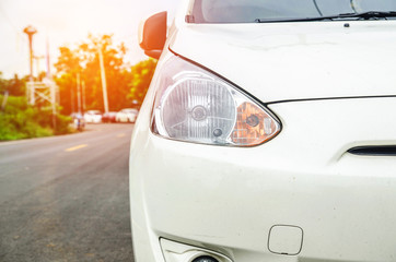 Naklejka premium Close up front of new silver car parking on the asphalt road