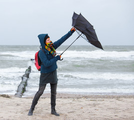 a woman tries to hold an umbrella in a storm
