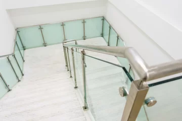 Store enrouleur occultant Escaliers Escaliers modernes en marbre blanc avec garde-corps en acier et en verre dans un nouveau bâtiment moderne.