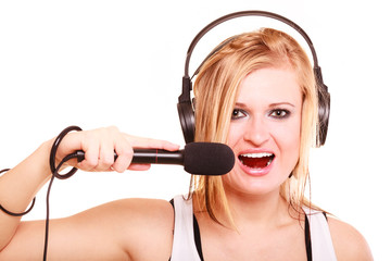 Woman singing to microphone wearing headphones