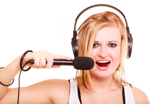 Woman singing to microphone wearing headphones