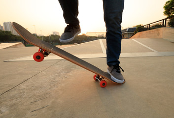 Fototapeta na wymiar skateboarder legs skateboarding on skatepark