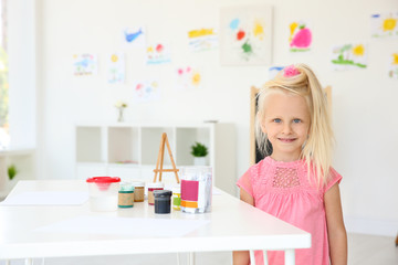 Little girl at painting lesson in classroom