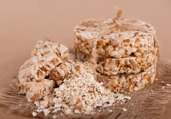 Round cereal crispbread tied with rope, crumbs on surface. Rustic style.