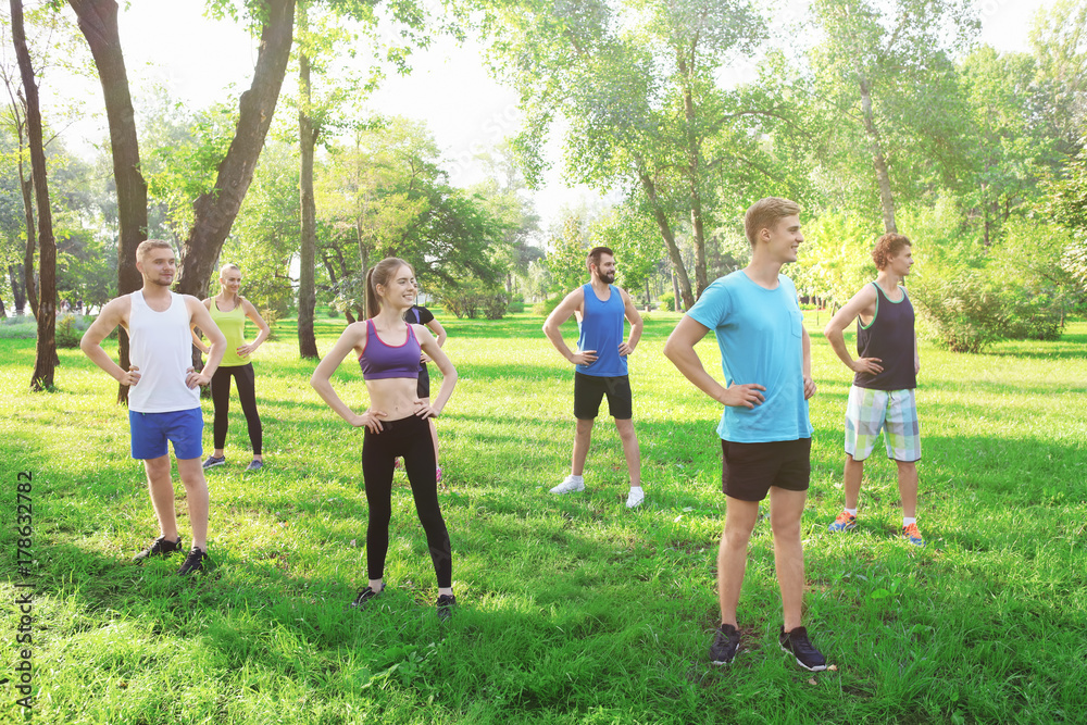 Wall mural Group of young people training in park