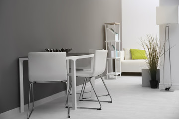 Modern room interior with white chairs and table