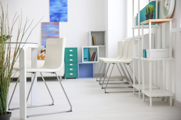 Modern room interior with white chairs and shelving unit