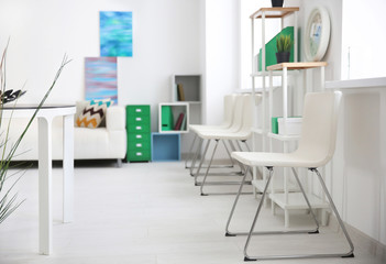 Modern room interior with white chairs and shelving unit