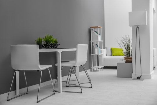 Modern room interior with white chairs and table