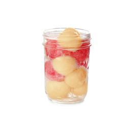 Glass jar with melon balls on white background