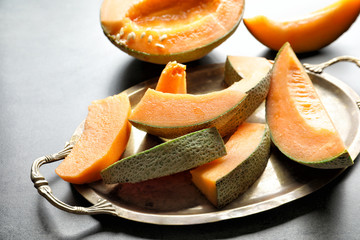 Tray with sliced melon on grey background