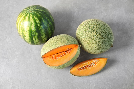 Fresh ripe melons and watermelon on grey background