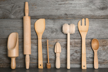 Set of kitchen utensils on table against wooden wall