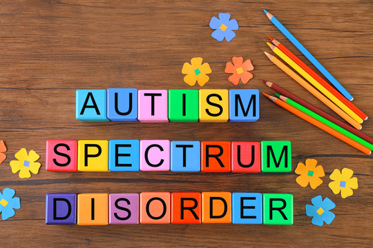 Colorful cubes with text on wooden background. Autism concept