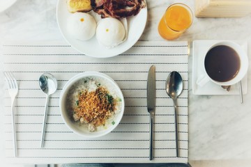 Boiled rice with pork, Steam Buns, bacon, bread and orange juice of breakfast in the morning