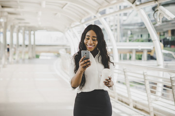 Young business woman looking on her cell phone during working to work.