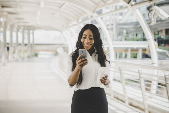 Young Business Woman Looking On Her Cell Phone During Working To Work.