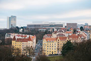 Obraz premium View from a high point. A beautiful view from above on the streets, roads and roofs of houses in Prague. Traditional ancient urban architecture. The road, the car is parked, ordinary life.
