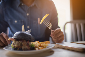 man eating hamburger at cafe