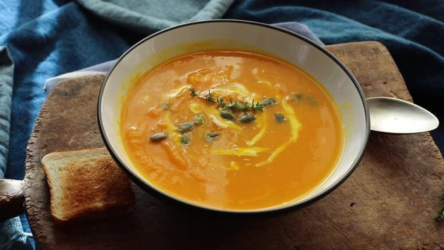Traditional pumpkin soup with cream and pumpkin seeds.