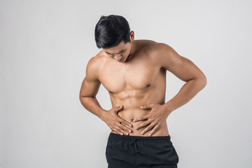 Young handsome Muscular man has abdominal pain isolated on white background.