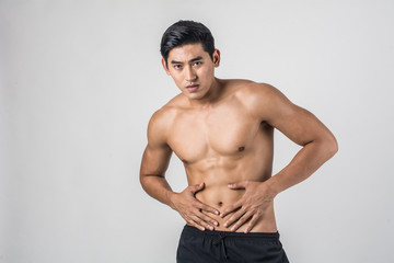 Young handsome Muscular man has abdominal pain isolated on white background.