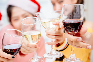 Groups of friends are Asian men and women decorated the Christmas tree. To celebrate the Christmas season. They drink wine and champagne to enjoy together happily.