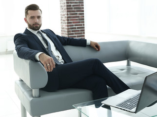 businessman sitting in the lobby of a modern office.