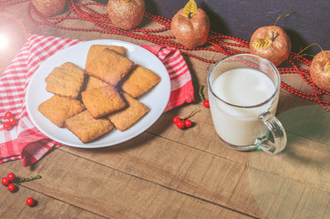 Biscuits, milk, red napkin, Christmas decor with free space for text. Top view