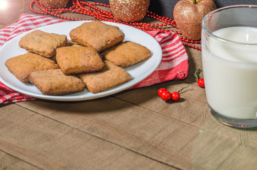 Biscuits, milk, red napkin, Christmas decor with free space for text.
