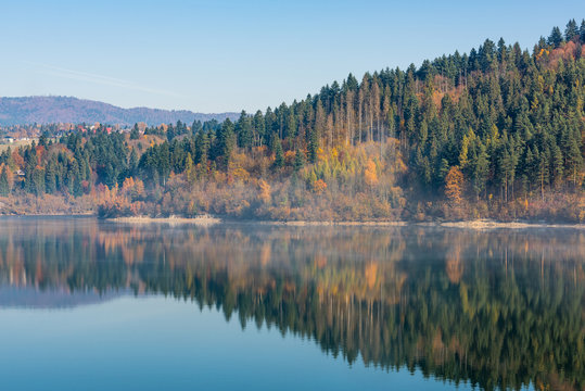 Autumn foliage reflect in calm lake © marcin jucha