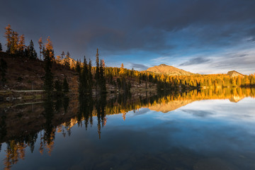 Stnning sunset last golden light over alpine lake nad peaks