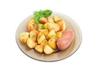 Fried potatoes with wieners on dark glass dish