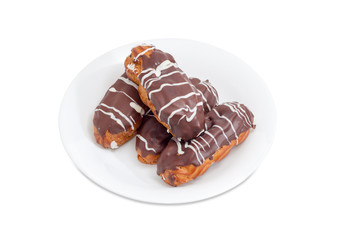 Eclairs with chocolate icing on a white dish