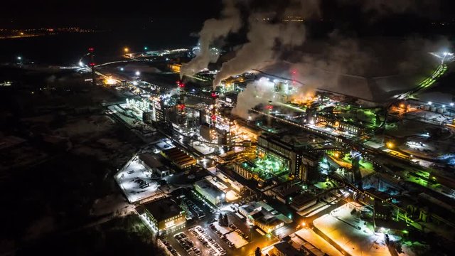 Aerial view of Oil refinery timalapse at night. Aerial footage.Oil refinery time lapse footage. Top view. Smokestacks from big pipes.