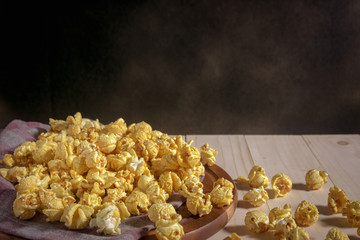 Caramel covered popcorn on wooden table, mystic photography and selective focus