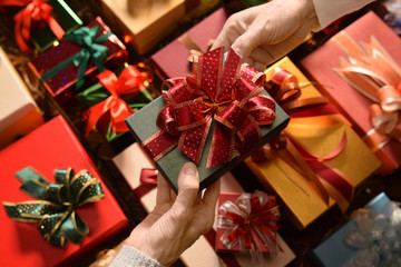 People giving presents to one another in Christmas and New year Festivals with boxes of presents in the background