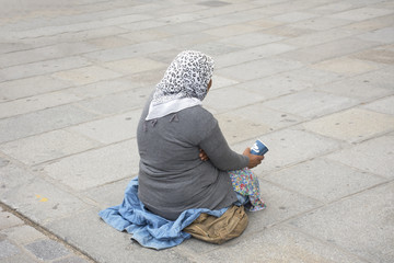 Old woman beggar sitting begging money from  French people and foreigner travlers at walkway for go...