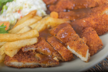 Chicken chop with vegetable and black pepper sauce in plate over wooden table