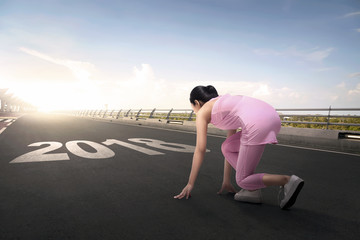 Young asian athlete woman ready to running with 2018 number