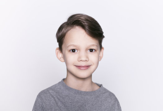 Portrait of young happy smiling brunette boy looking at camera isolated.