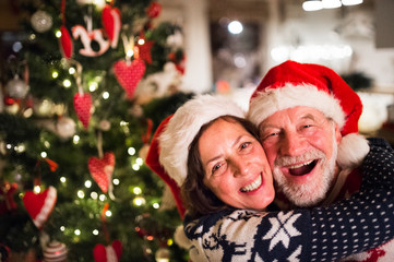 Fototapeta na wymiar Senior couple with Santa hats at Christmas time.