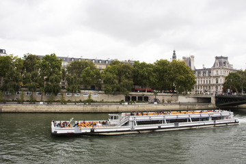 Fototapeta na wymiar River Cruises sailing bring travelers passengers tour and looking old town Paris city at riverside of Seine river on September 6, 2017 in Paris, France
