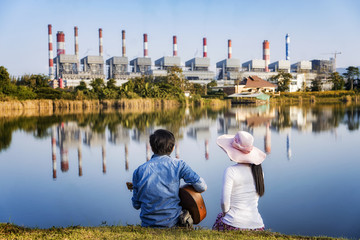Lovers sit and play guitar poolside industry.