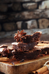 chocolate brownie cake dessert with cinnamon and spices on a wooden background.